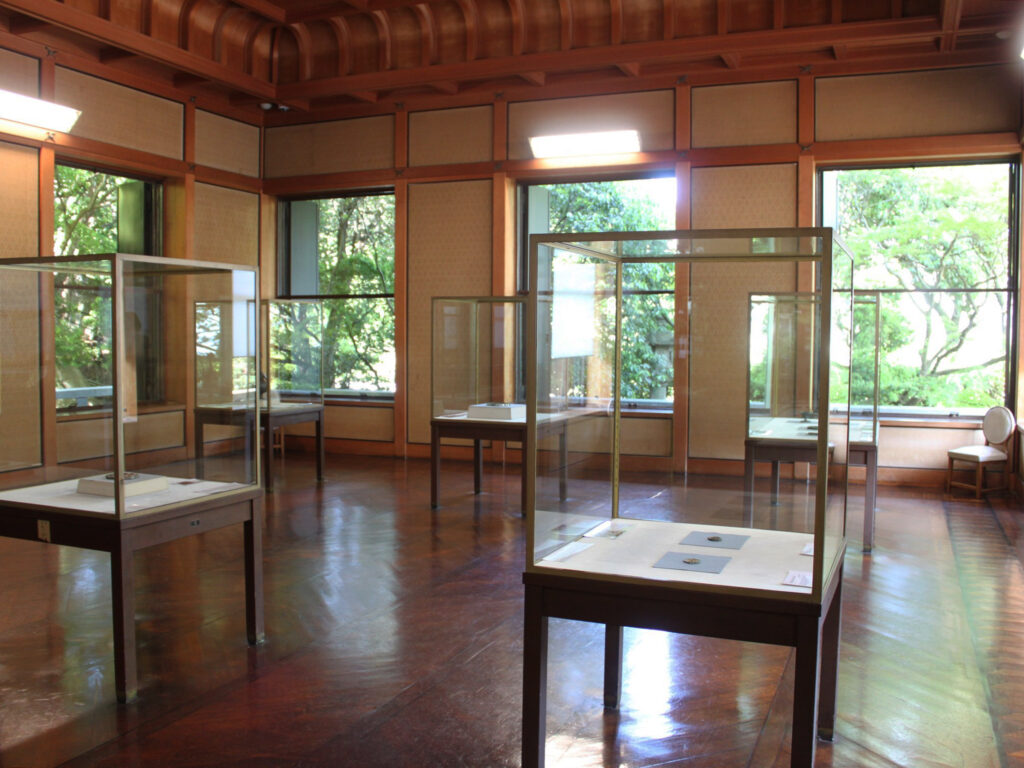 大きな窓越し、庭園の緑が絶妙な借景に。春季展はいきいきとした新緑、秋季展は鮮やかな紅葉をバックに