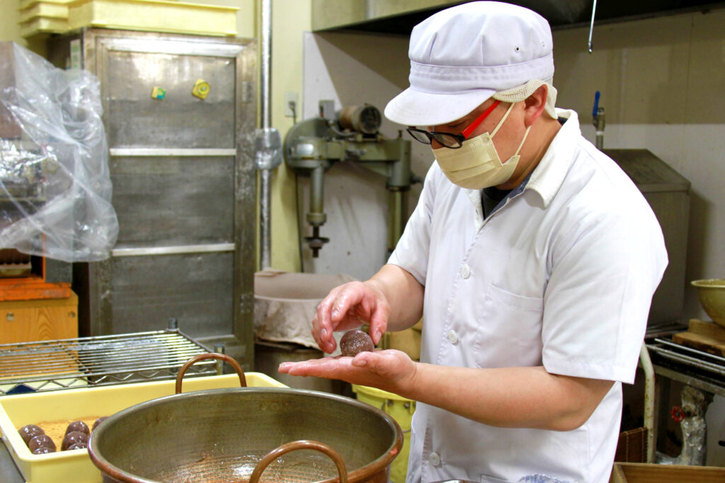 店奥の工房で宝珠をつくる明広さん。慣れた手つきであん玉を包んでいきます