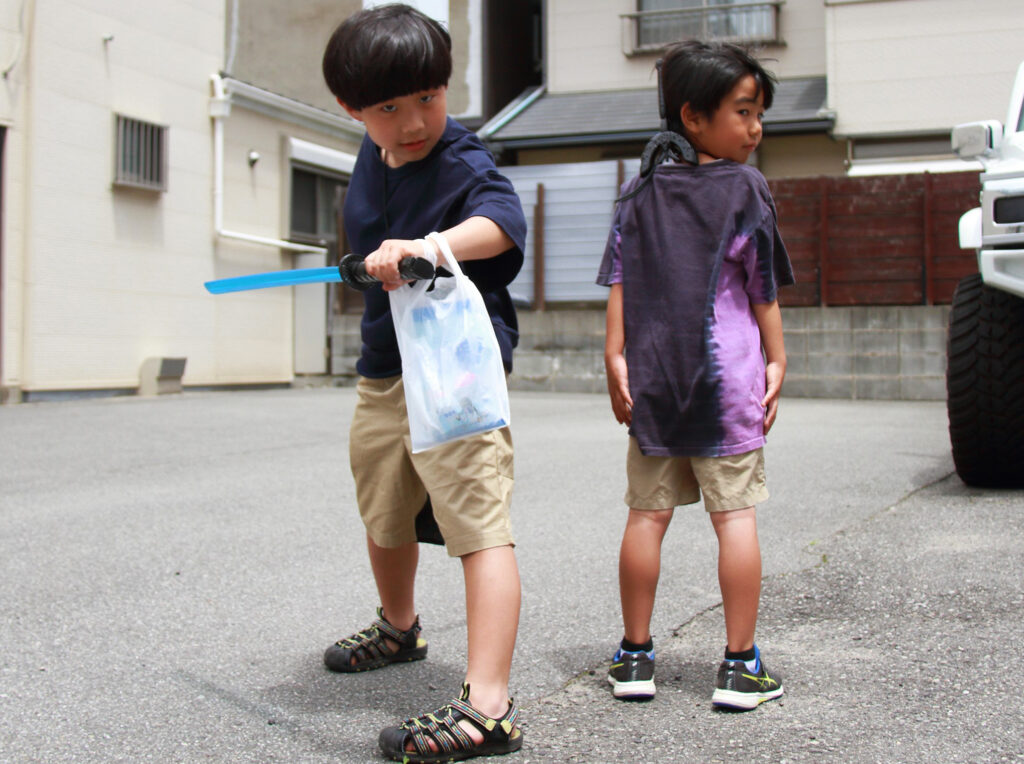 おもちゃのつちだでゲットした刀でポーズを決めてくれる男の子。コインケース作りも「楽しかった！」とご満悦