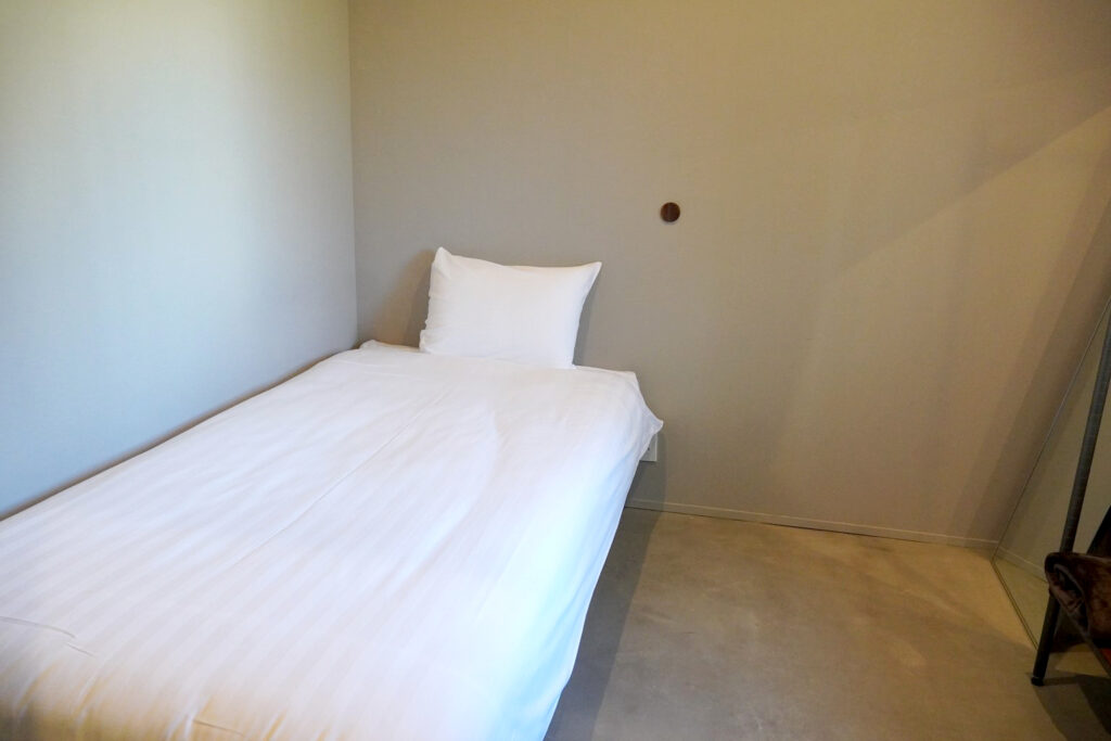 ベッドと小さなテーブルがあるシンプルな部屋