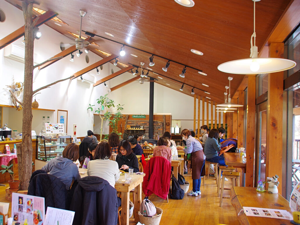店内は天井が高く開放的な山小屋風。奥に暖炉