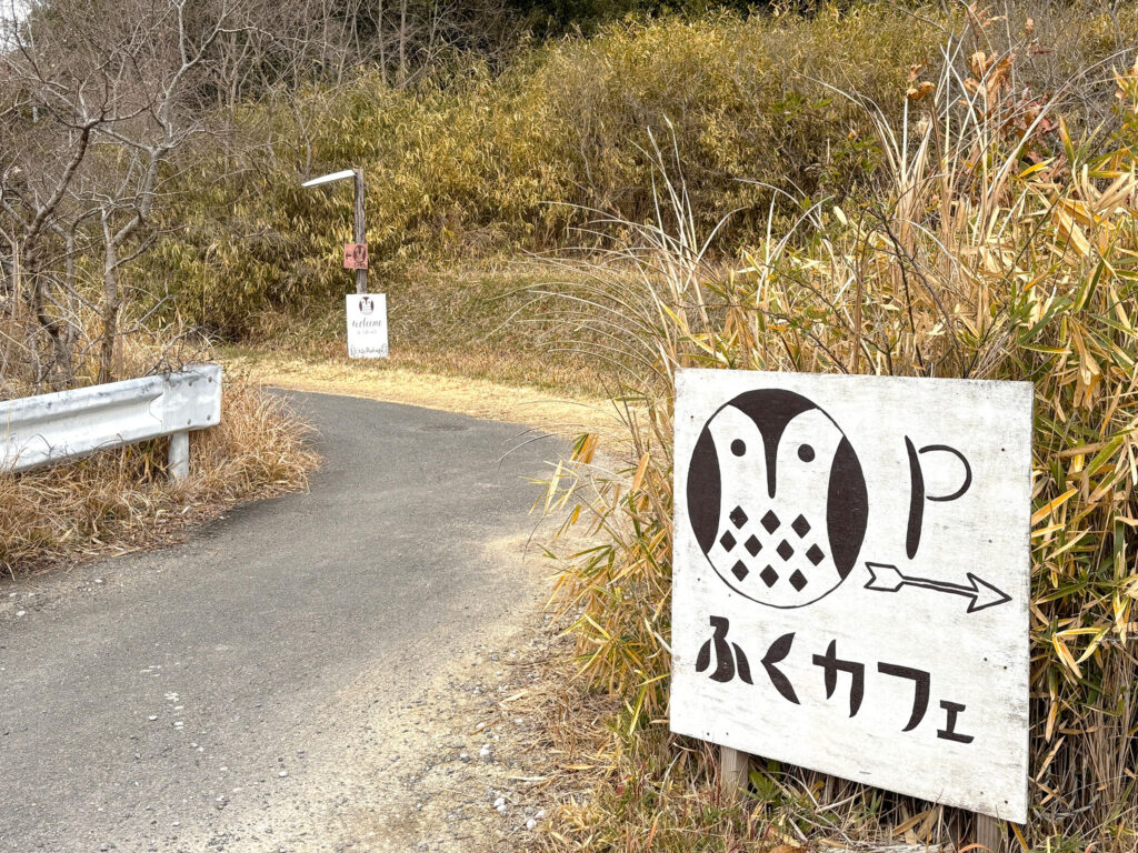 ふくろうの止まり木のような看板がお店へ目印